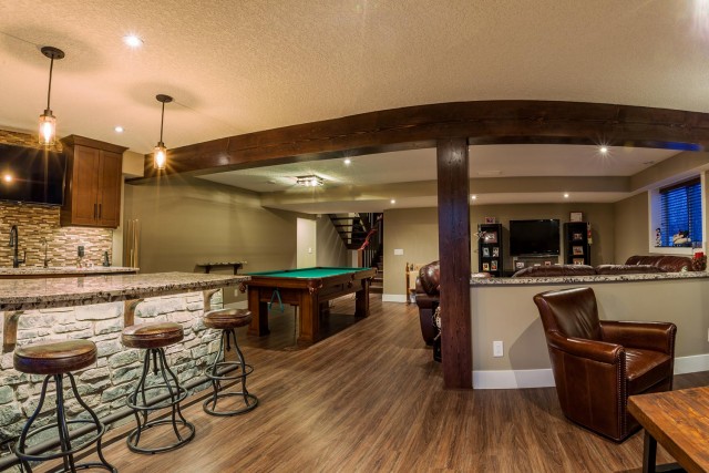 Modern living room interior with bar setting with marble stone leather cover bar stools pool table in the middle of the room with leather couches