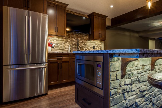 Modern Kitchen Interior with double door fridge and marble countertop with microwave installed on the kitchen island stone decorated with