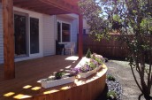 Modern Patio wooden deck with minimal garden in grey stones