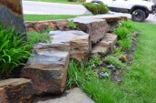 Beautiful brown stoneworks placed on the front yard area with small plants