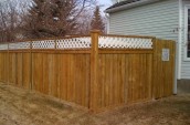 Wooden fence with the check pattern on the top placing just outside of house