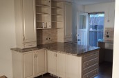 Modern kitchen interior renovation with marble countertop and cream color closets right in front of backdoor of the house