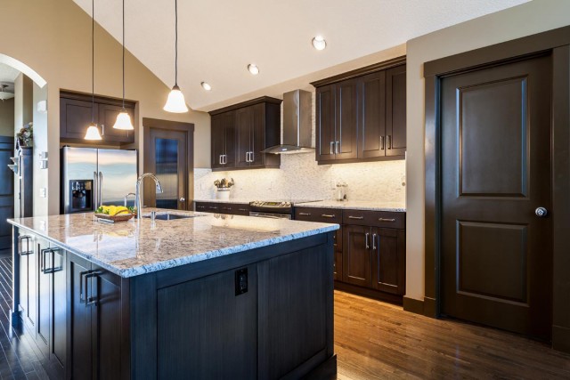 Modern Kitchen Interior in black closets and kitchen island with marble countertop