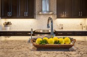 Modern Kitchen Interior in black closets and kitchen island with marble countertop and yellow round fruit ornaments