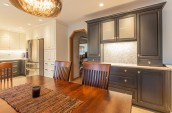 wooden table with protective mat in centre and open plan kitchen in background
