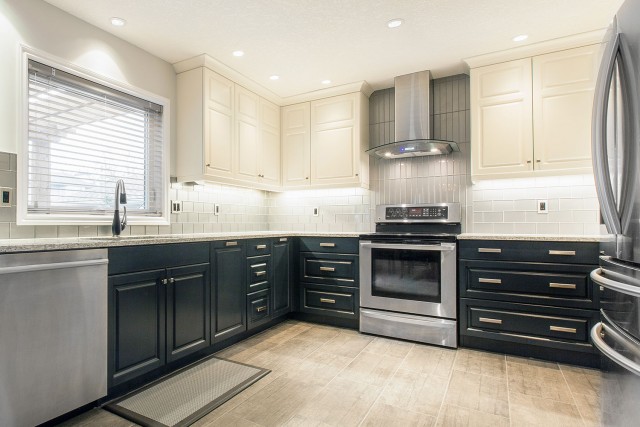 oven surrounded by drawers with extractor surrounded by cabinets