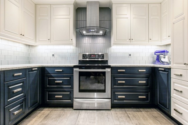 oven surrounded by drawers with extractor surrounded by cabinets