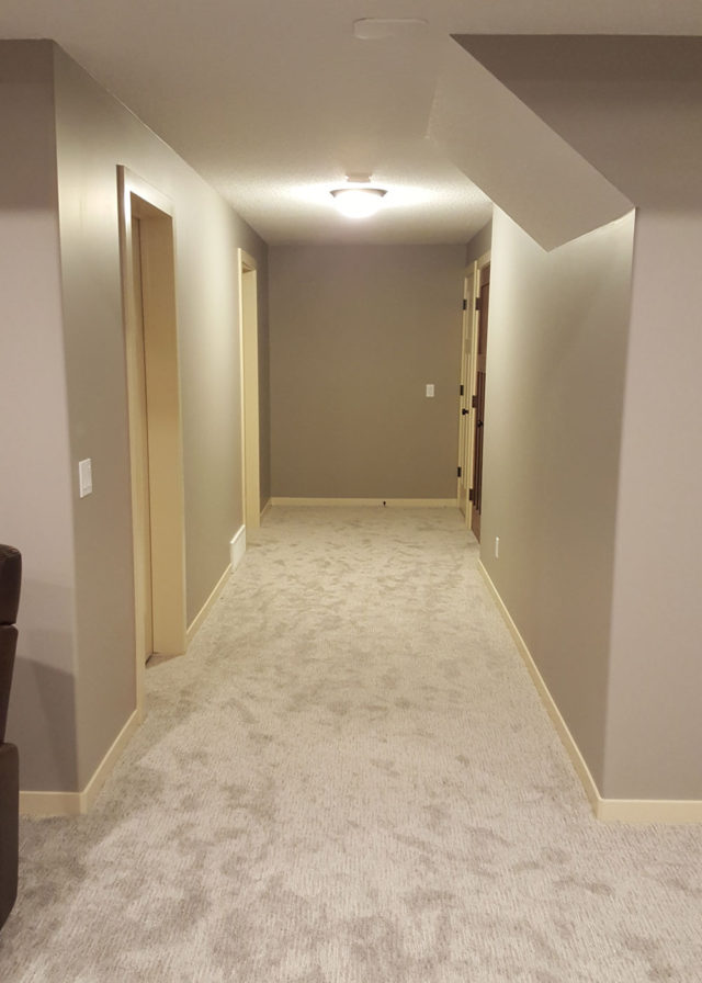 carpeted hallway with two doors to left and one to right