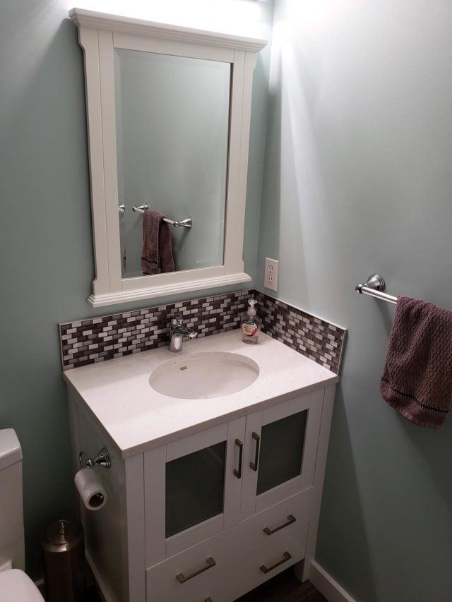 basin and mirror with towel hanging on towel rack