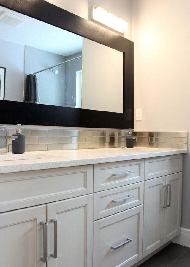 large rectangular mirror above drawers and cabinets in bathroom
